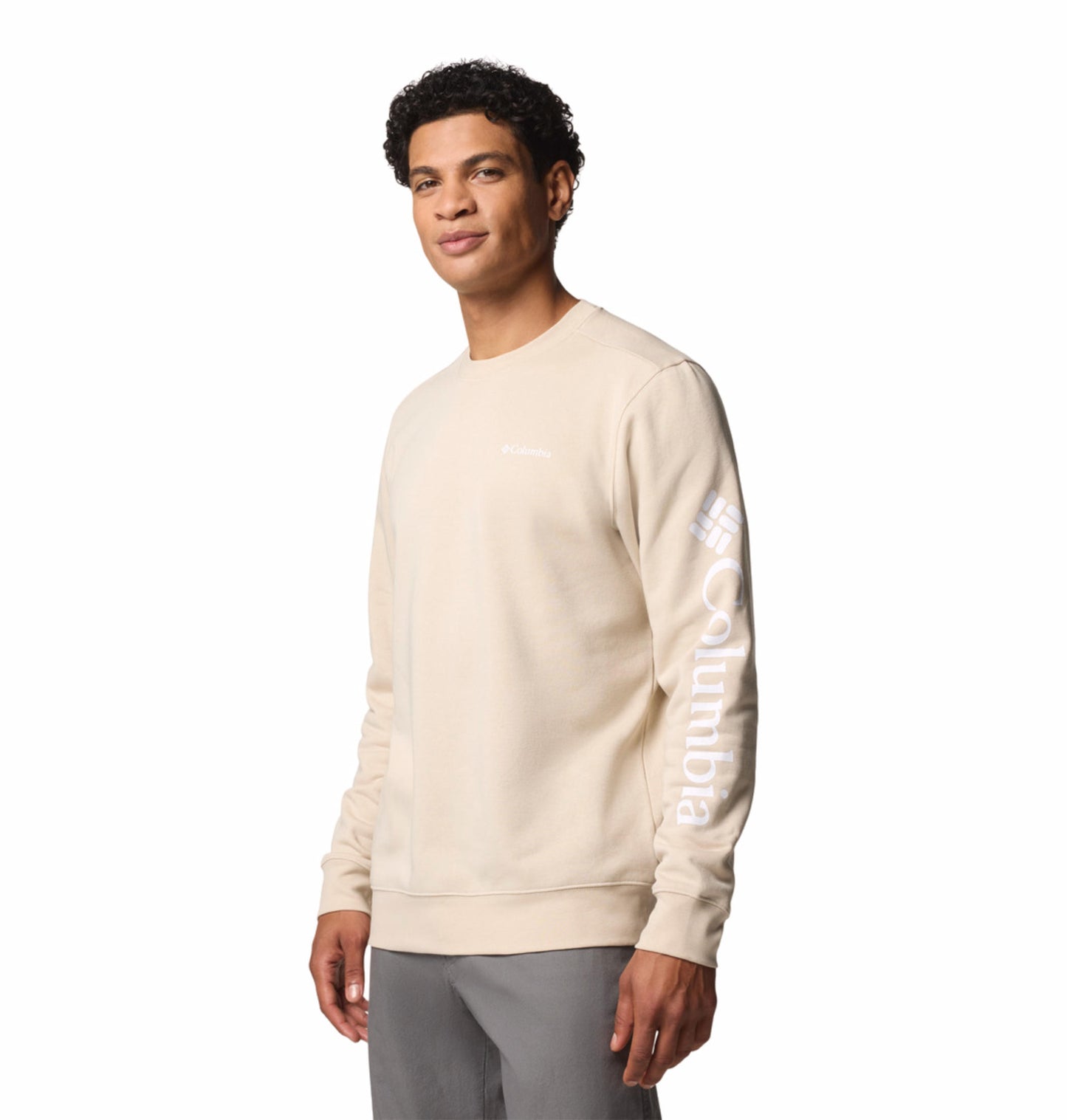 A man wearing a beige long-sleeved crew pullover with the text 'COLUMBIA' on the sleeve.