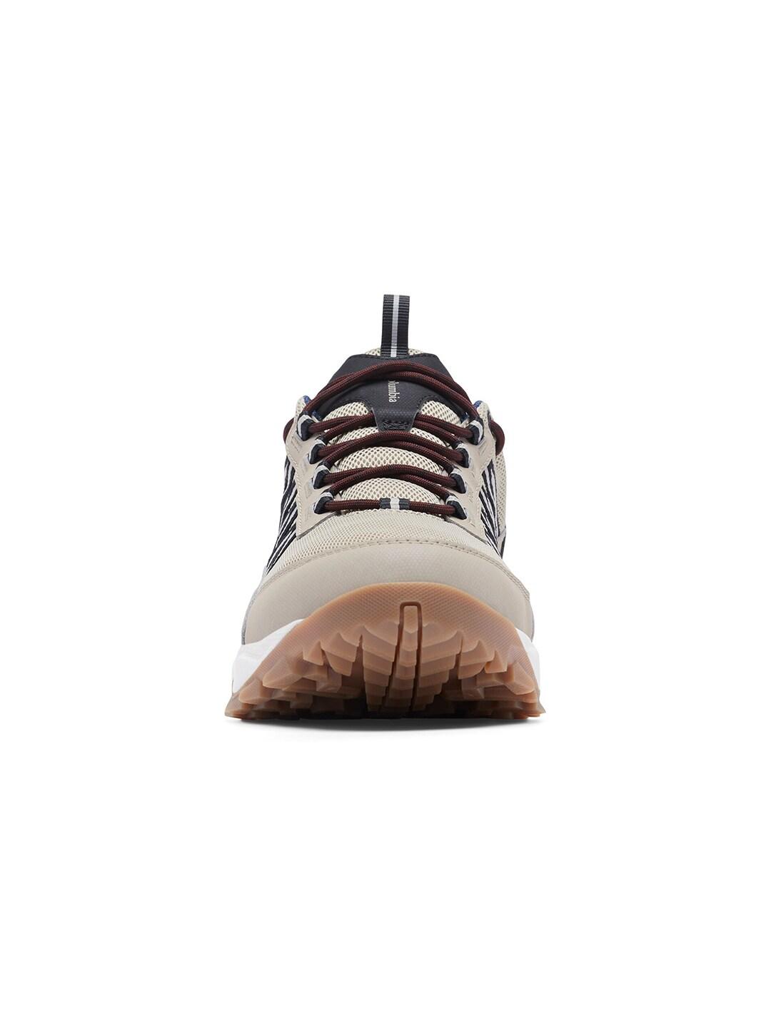 A beige Columbia men's casual shoe with a lace-up closure, featuring a combination of mesh upper, synthetic overlays, and a rubber outsole.